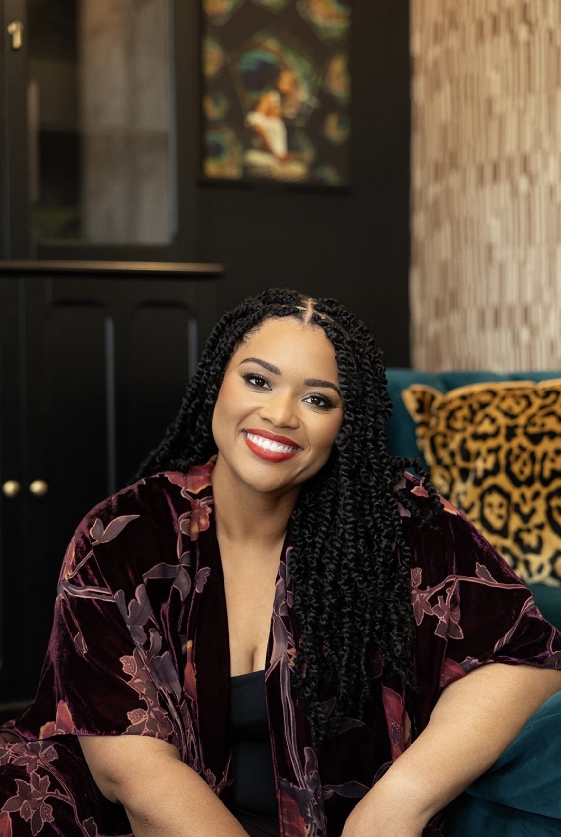 Dr. Monica Johnson, founder and psychologist at Kind Mind Psychology, smiling in a velvet floral robe