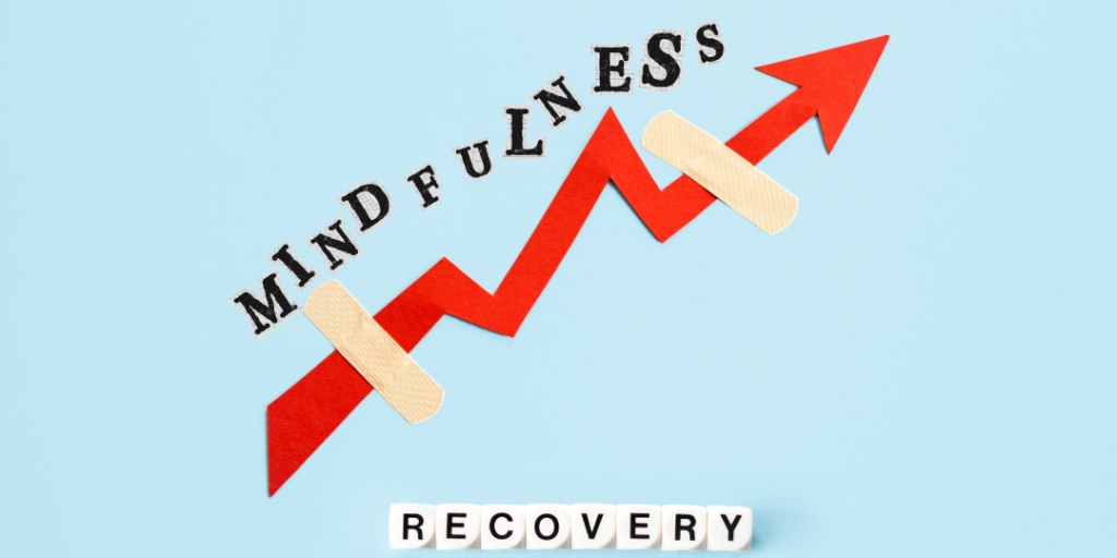 Red arrow rising upward with the word mindfulness and bandages above blocks spelling recovery