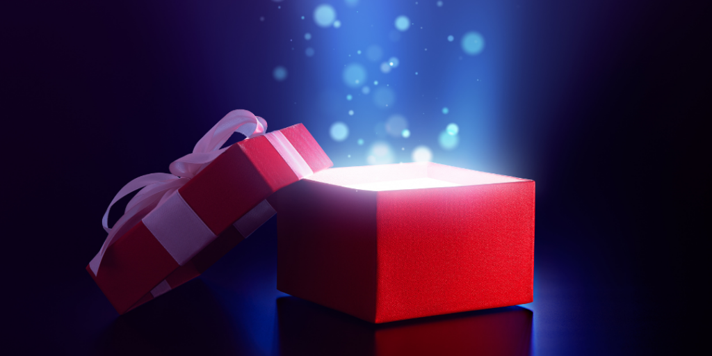 Open red gift box glowing with light and sparkles, representing the gift of feedback