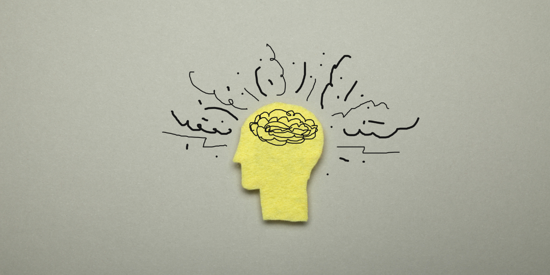 Yellow felt head cutout with a scribbled brain and jagged lines, representing ADHD and anxiety