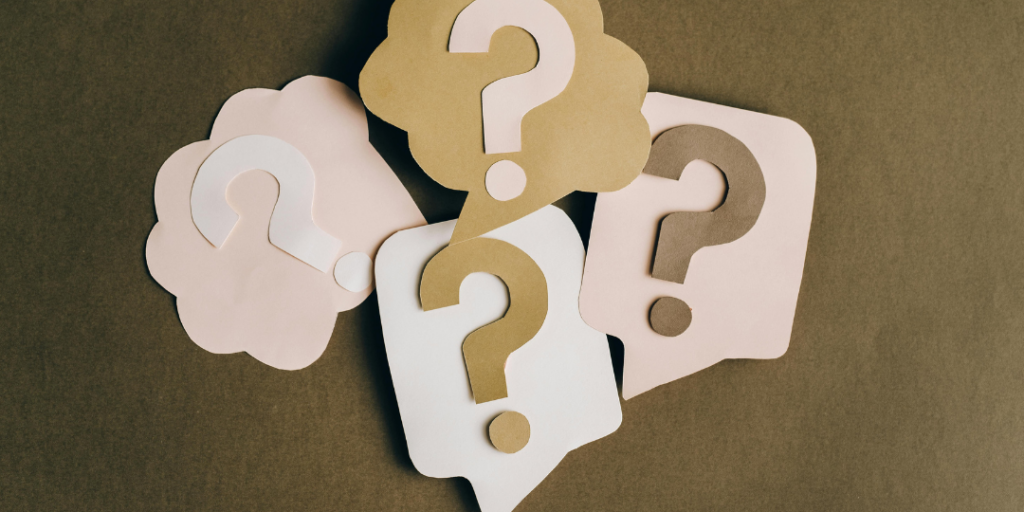 Paper cutout question marks in speech bubbles on a brown background, representing the question what is IFS therapy