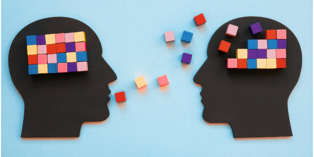 Two head silhouettes with colorful blocks for brains exchanging blocks, representing parts-based IFS therapy